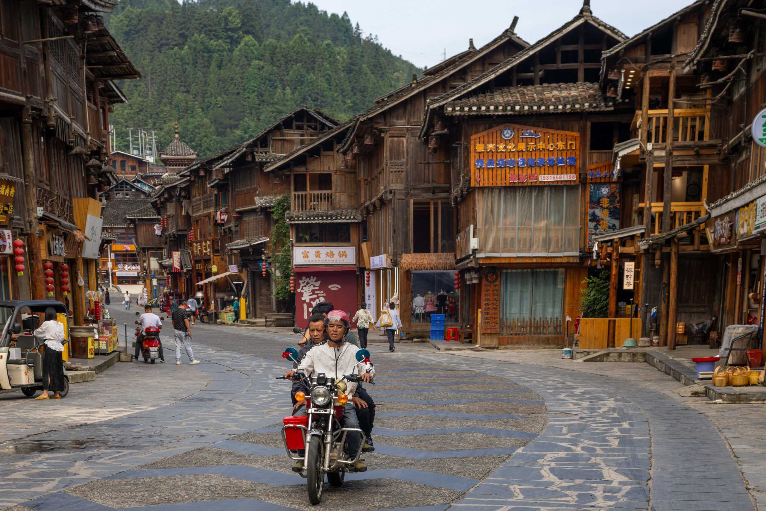 Stone-paved street lined with traditional wooden buildings in Zhaoxing Dong Village
